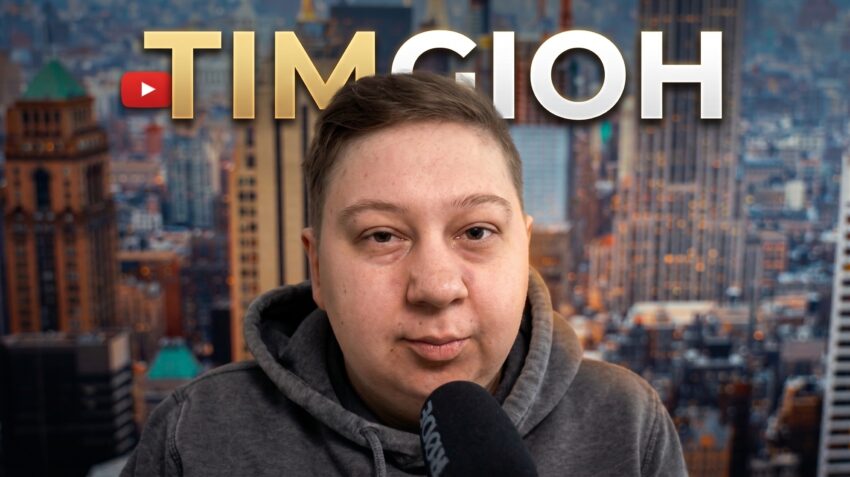 Timgioh im grauen Hoodie mit Mikrofon vor einer Großstadt-Skyline